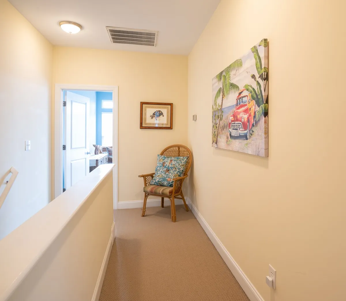 This image features a decorative painting and a comfortable chair placed near a doorway that leads into another room. The composition suggests a transitional space within the home, inviting guests to move from one area to another and potentially step out to explore more beyond the interior.